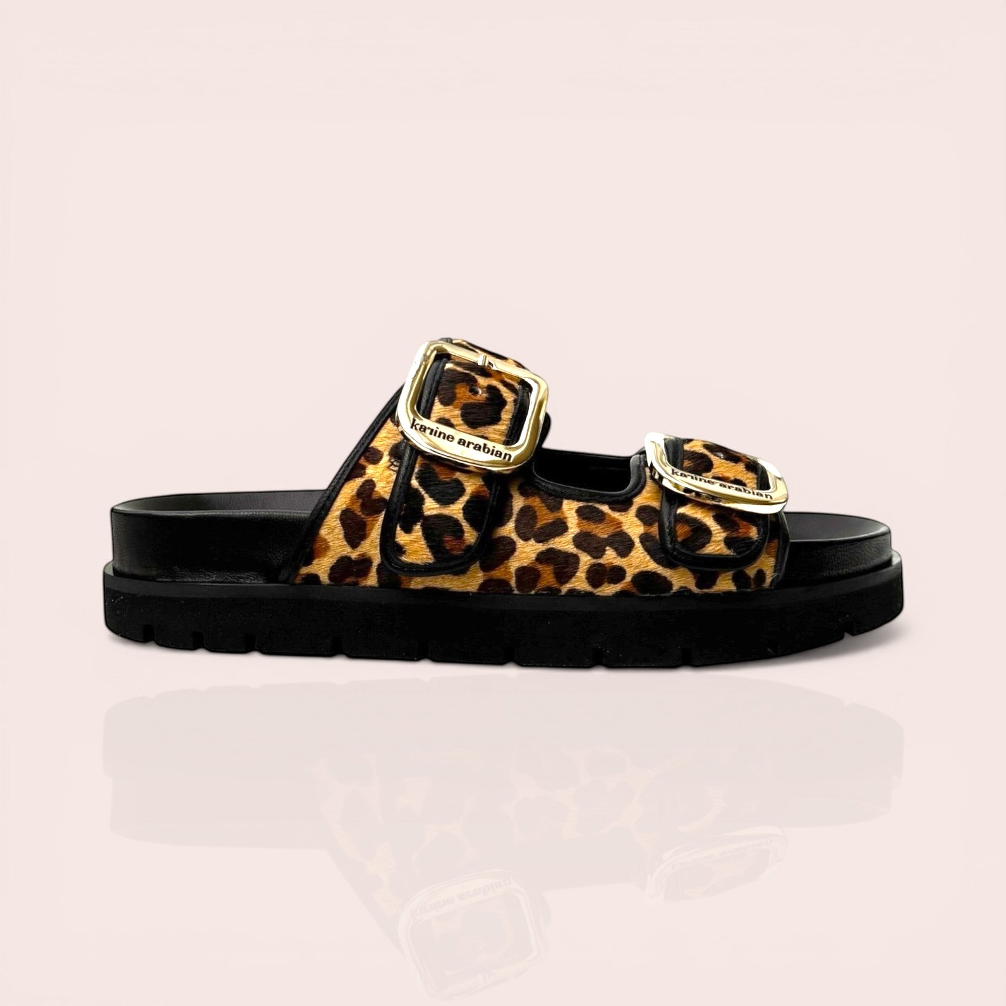 Black platform sandals with leopard print straps and gold-tone buckles. Features a chunky sole and adjustable straps.