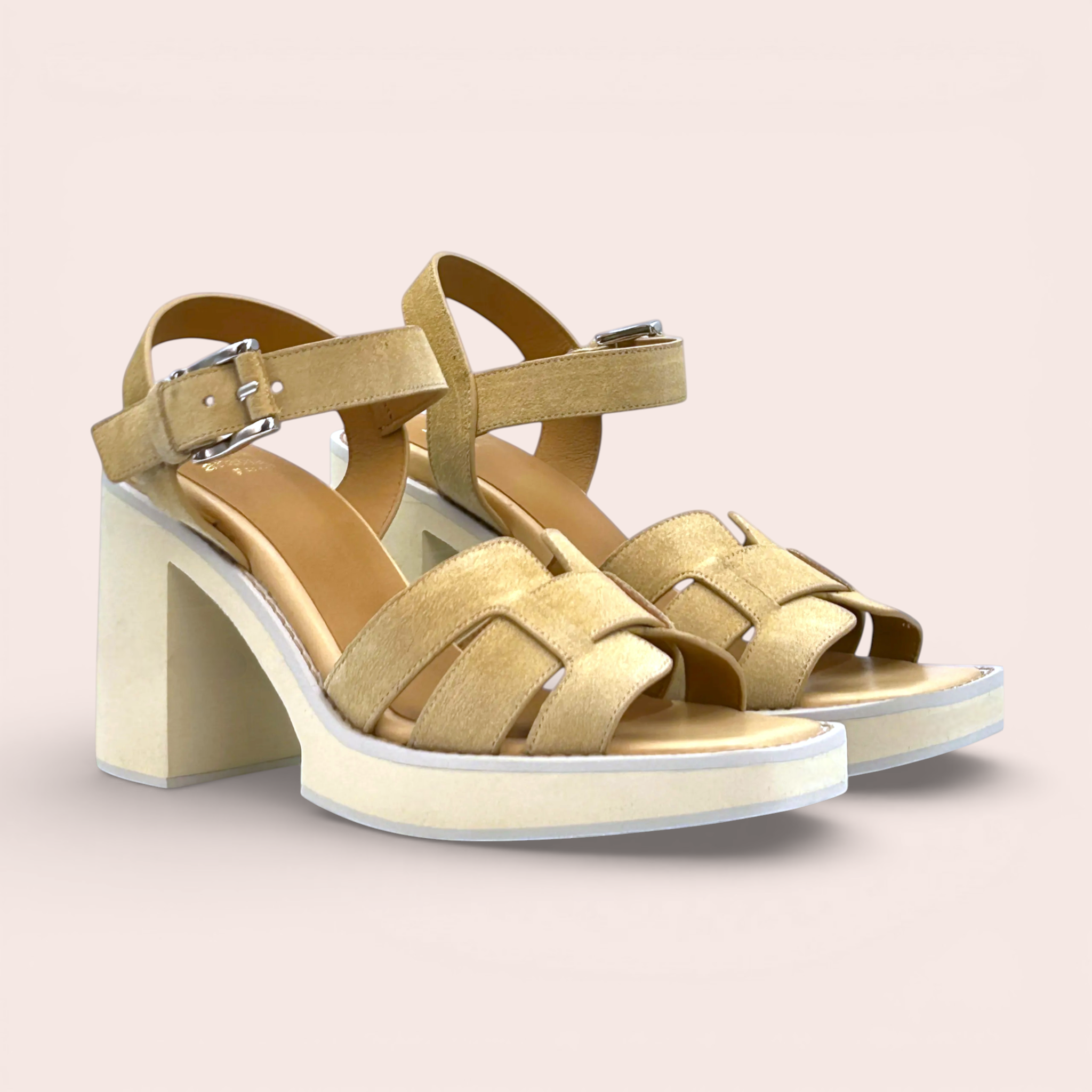 Beige suede platform sandals with interwoven straps and a block heel. Features an adjustable ankle strap with a silver buckle.