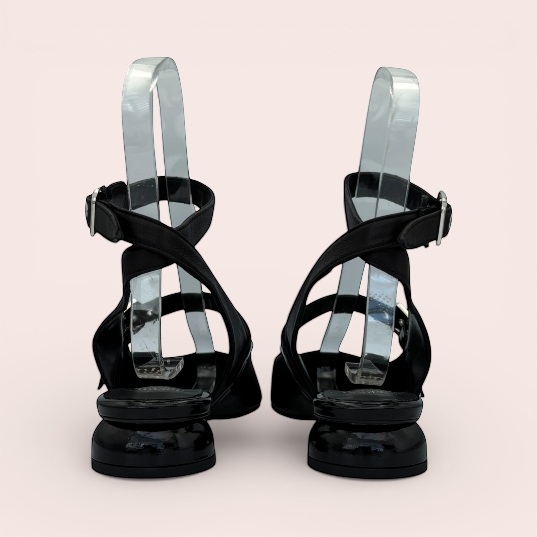 Black leather slingback sandals with pointed toe, ankle strap, silver square buckles, and a sculpted black lacquered block heel.