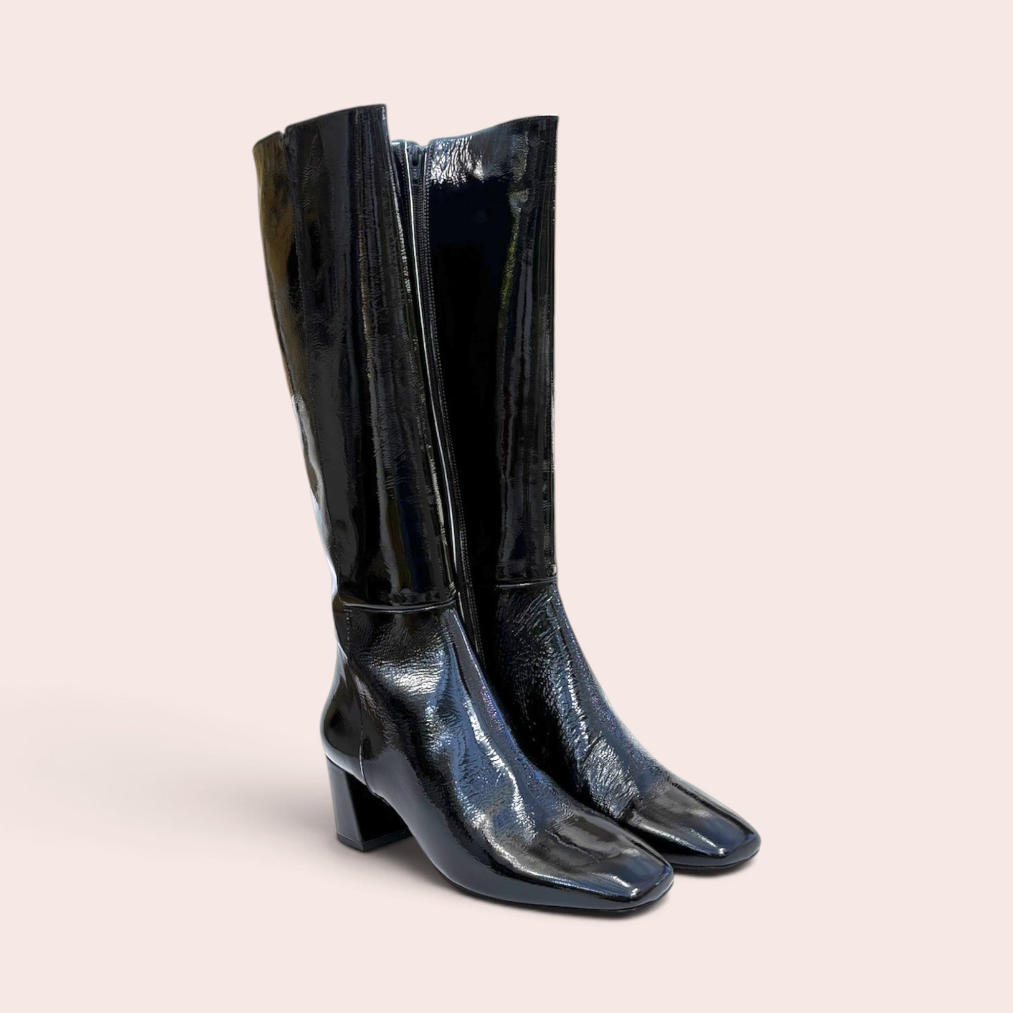 Pair of black patent leather knee-high boots featuring a square toe and a sturdy block heel against a neutral background.