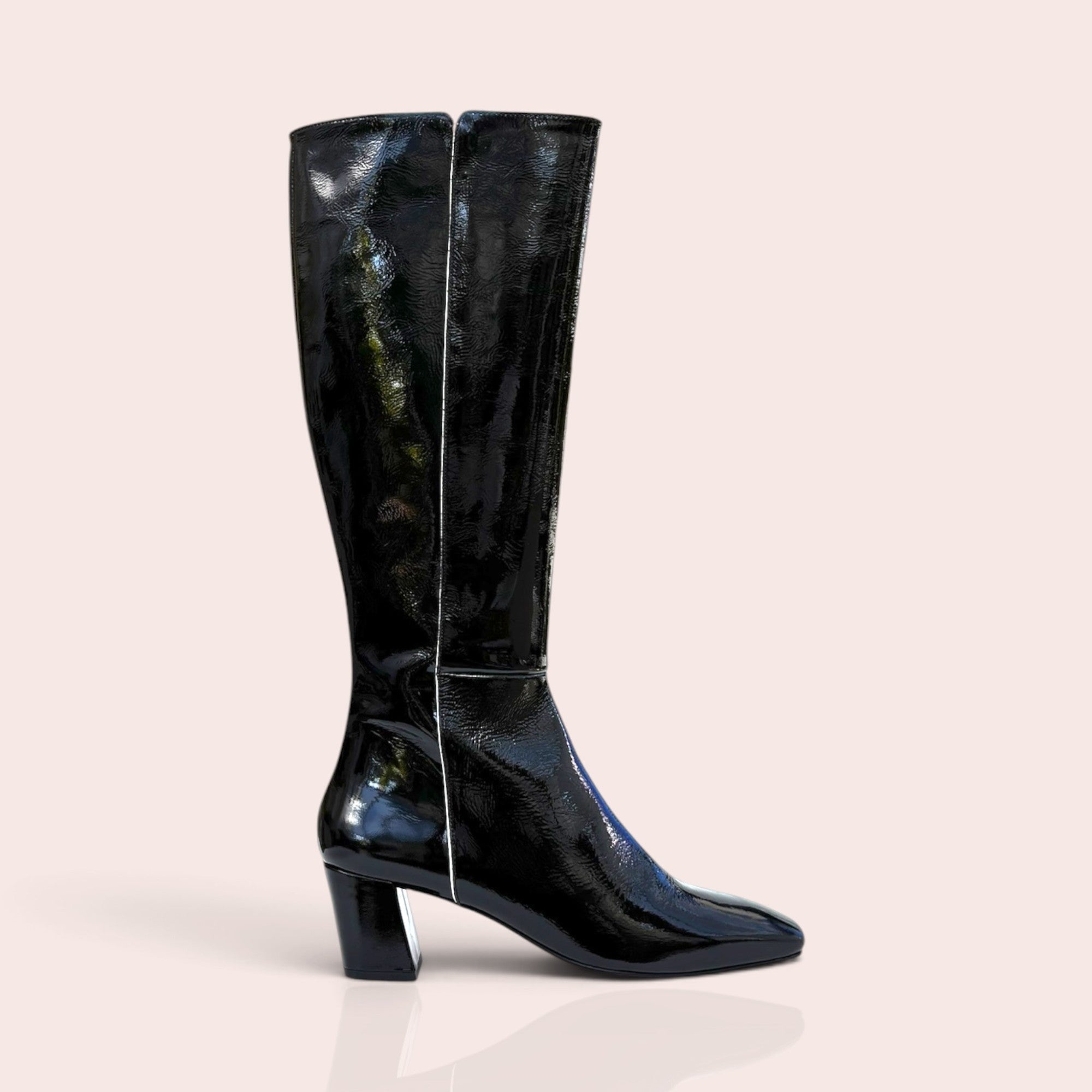 Black knee-high boots in glossy patent leather with a square toe and sturdy block heel, side profile view.