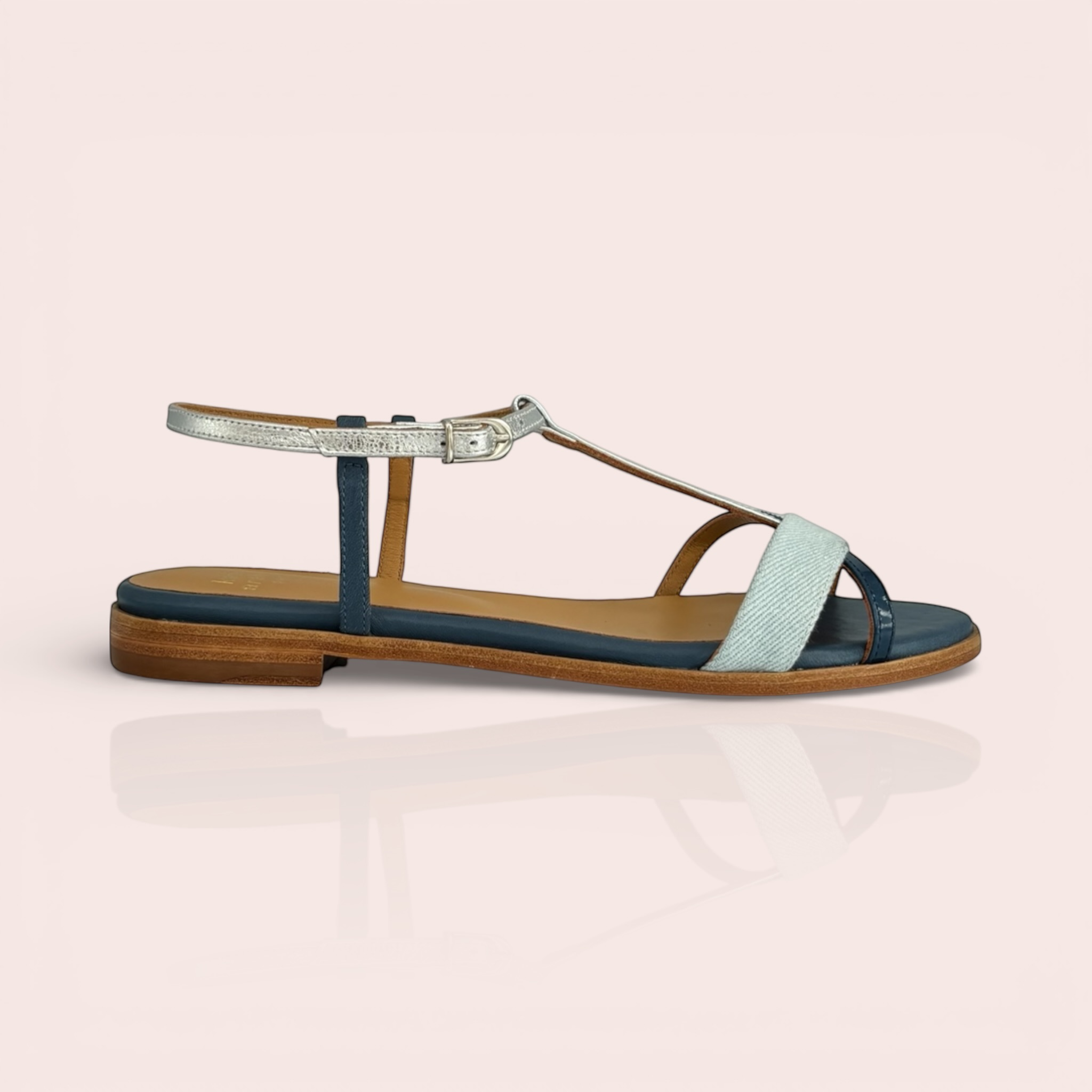 CARLA women's flat sandals in navy blue leather with a light blue denim strap and silver buckle detail. Features a t-strap design and a low wooden heel.