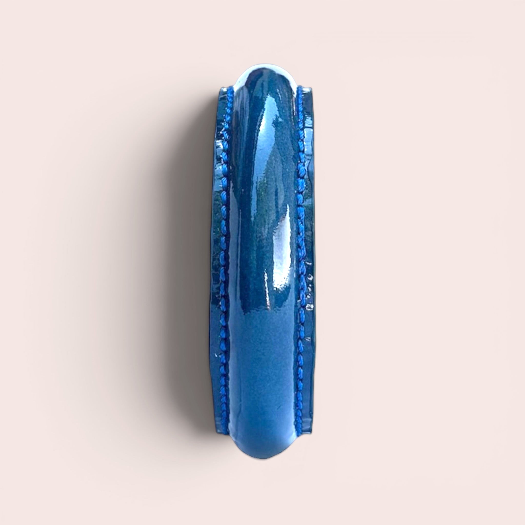 Duck blue patent leather bangle bracelet with visible stitched edges, side view on a neutral background.