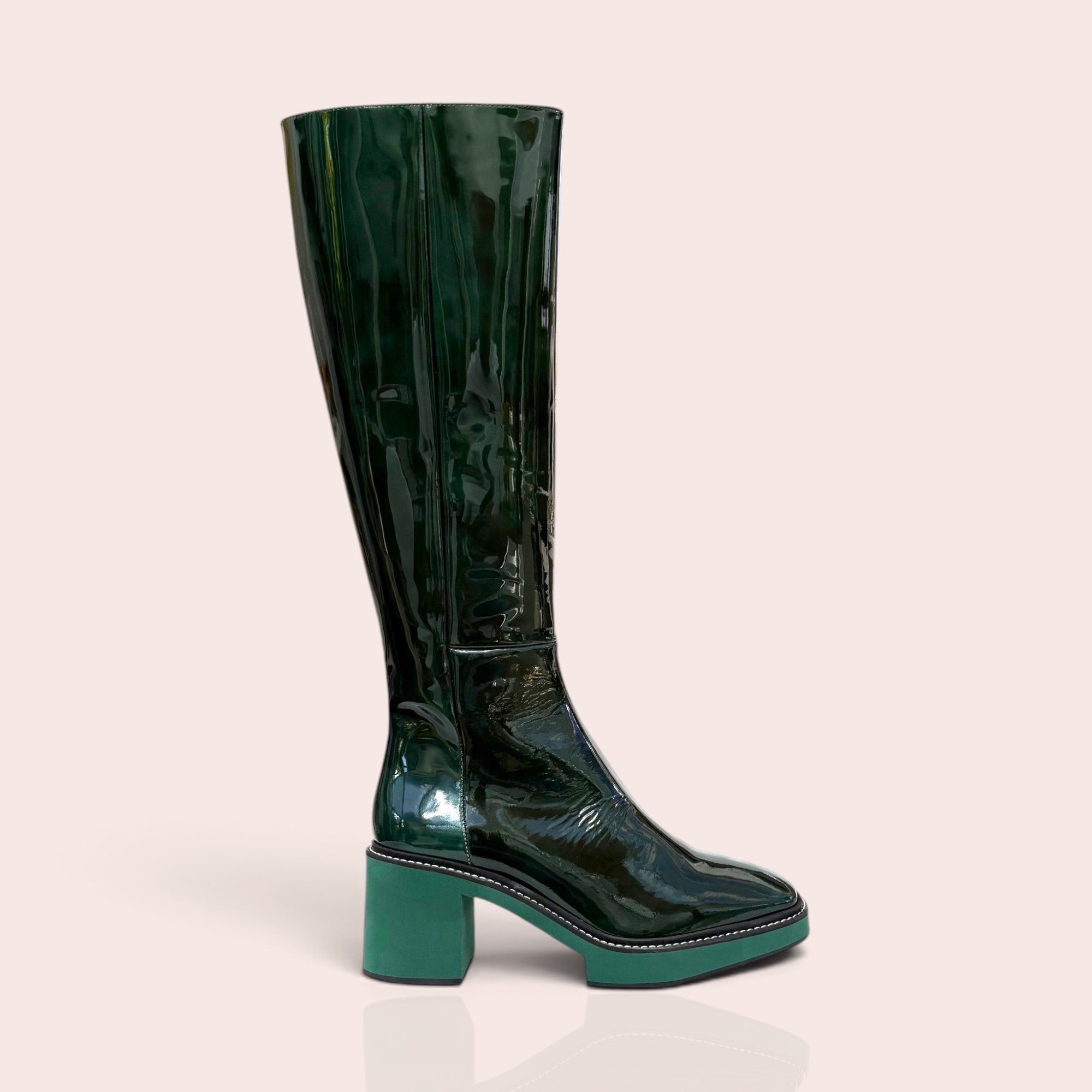 Forest green patent leather knee-high boots with a square toe, platform sole, and contrasting light green block heel.