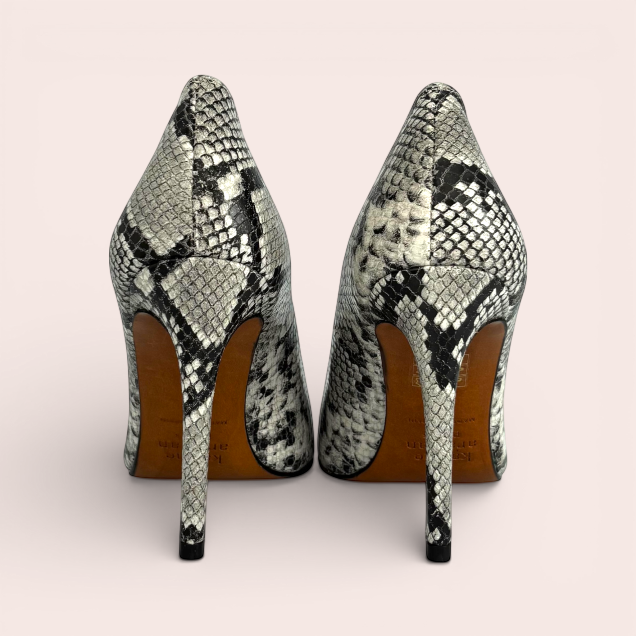Pointed-toe stiletto heels in a grey, black, and white snakeskin print. The shoes feature a classic silhouette with a high heel.