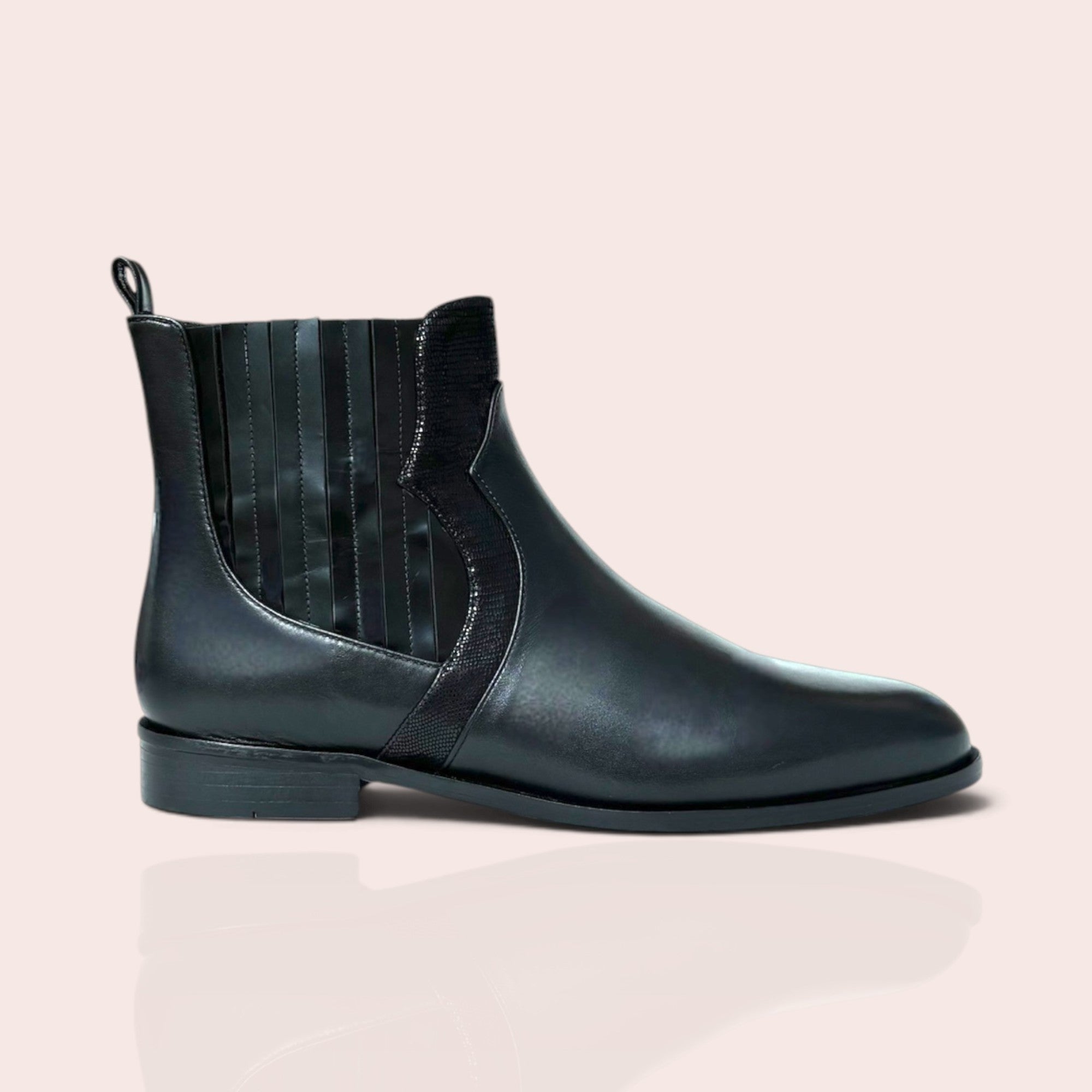 Black leather Chelsea ankle boots with textured elastic side panels, low-profile heel, and back pull tab.
