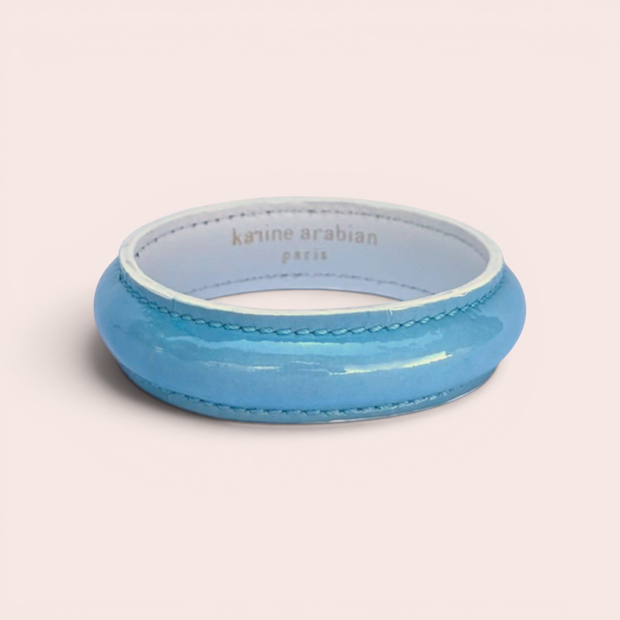 Karine Arabian bangle bracelet in glossy Maya blue patent leather with white leather trim and interior lining.