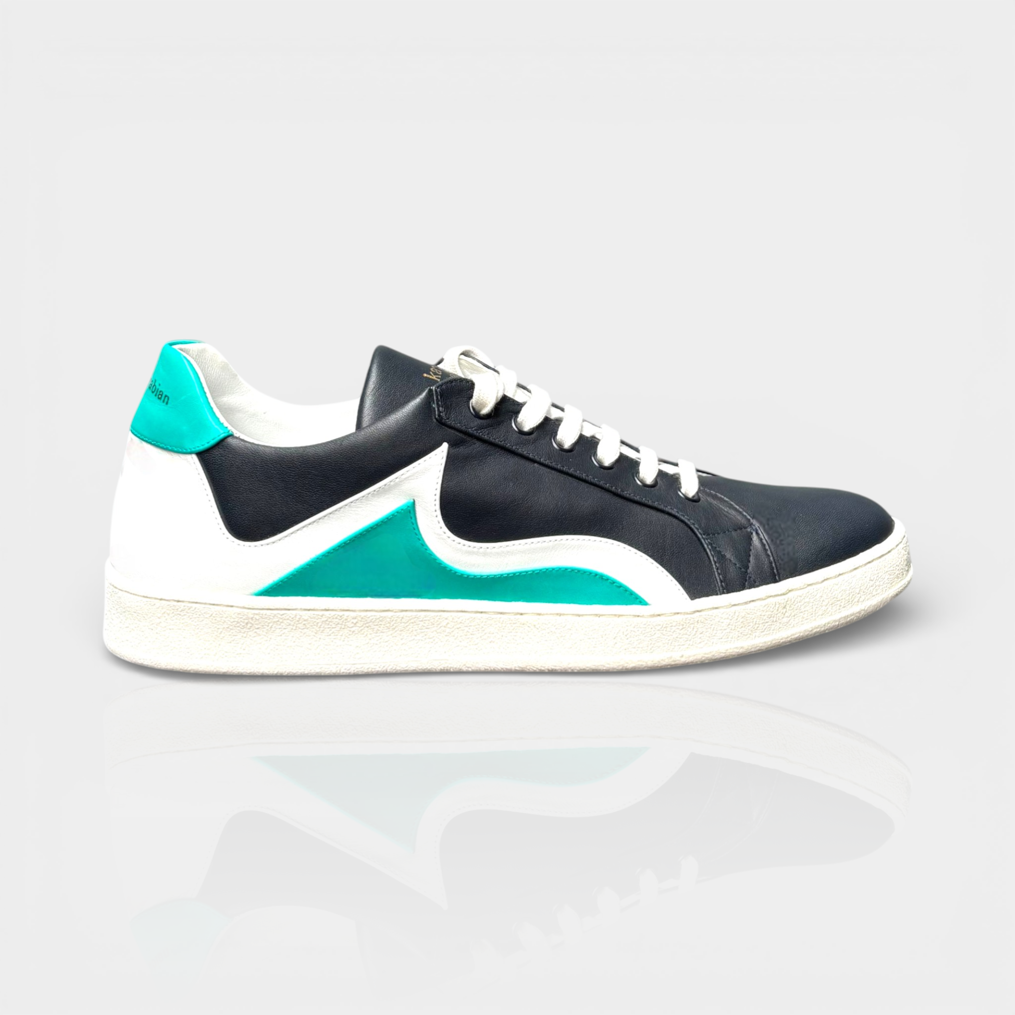 Men's navy leather sneaker with white and teal accents, lace-up closure, and textured sole.