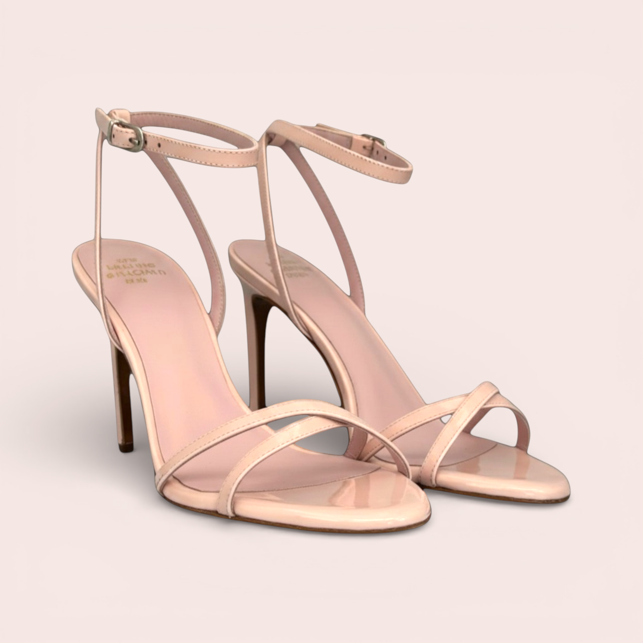 Pale pink patent leather CINDY sandals with thin ankle straps and a stiletto heel, displayed on clear acrylic forms.