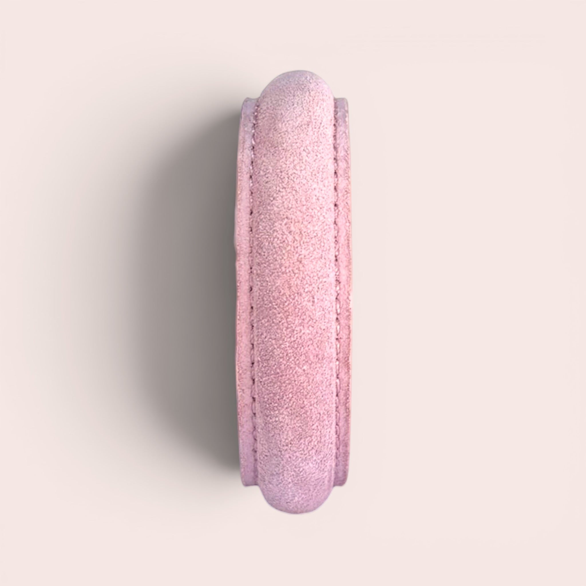 Pale pink suede leather bangle bracelet with stitched detailing, shown from a side profile view.