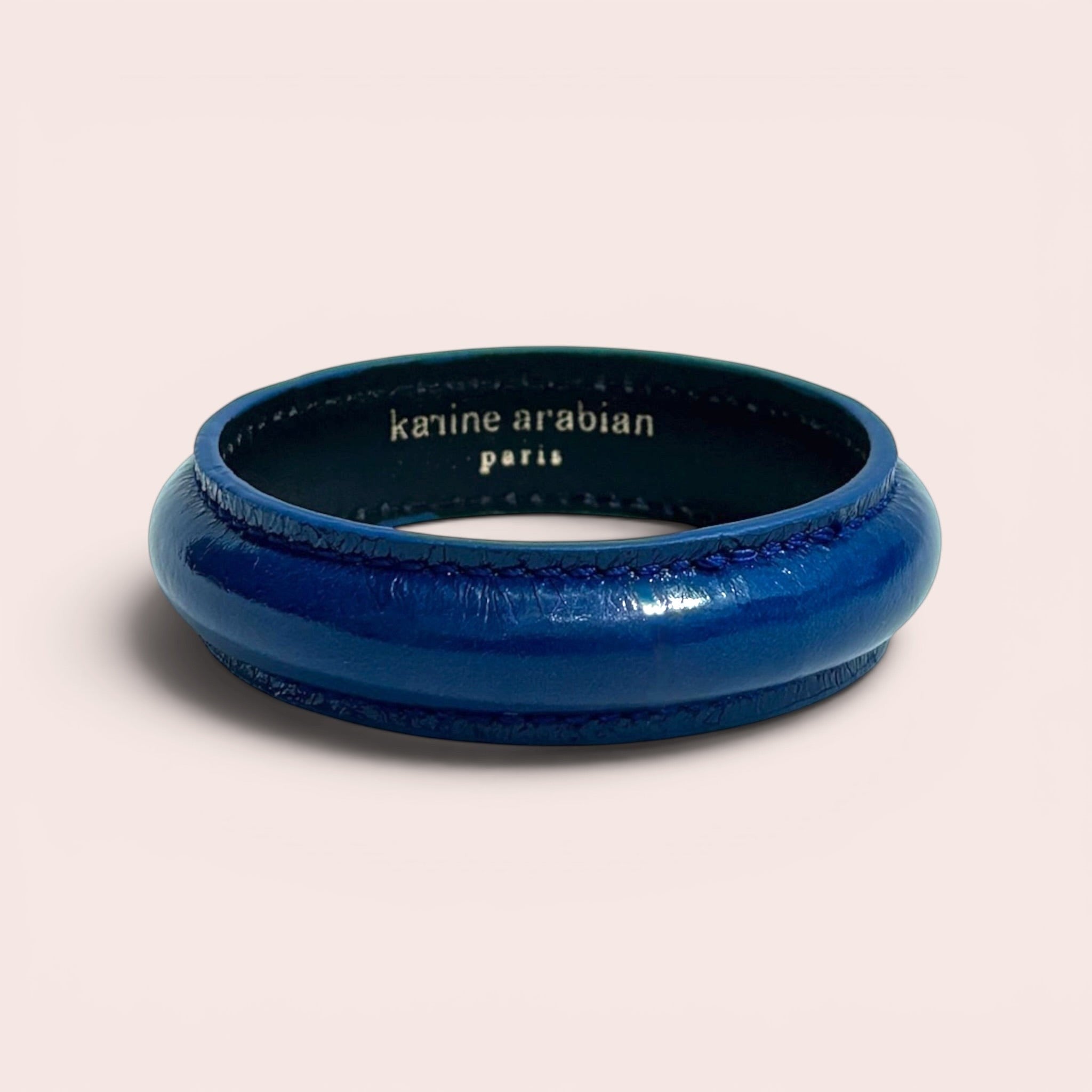 Peacock blue patent leather bangle bracelet by Karine Arabian with interior brand logo engraving