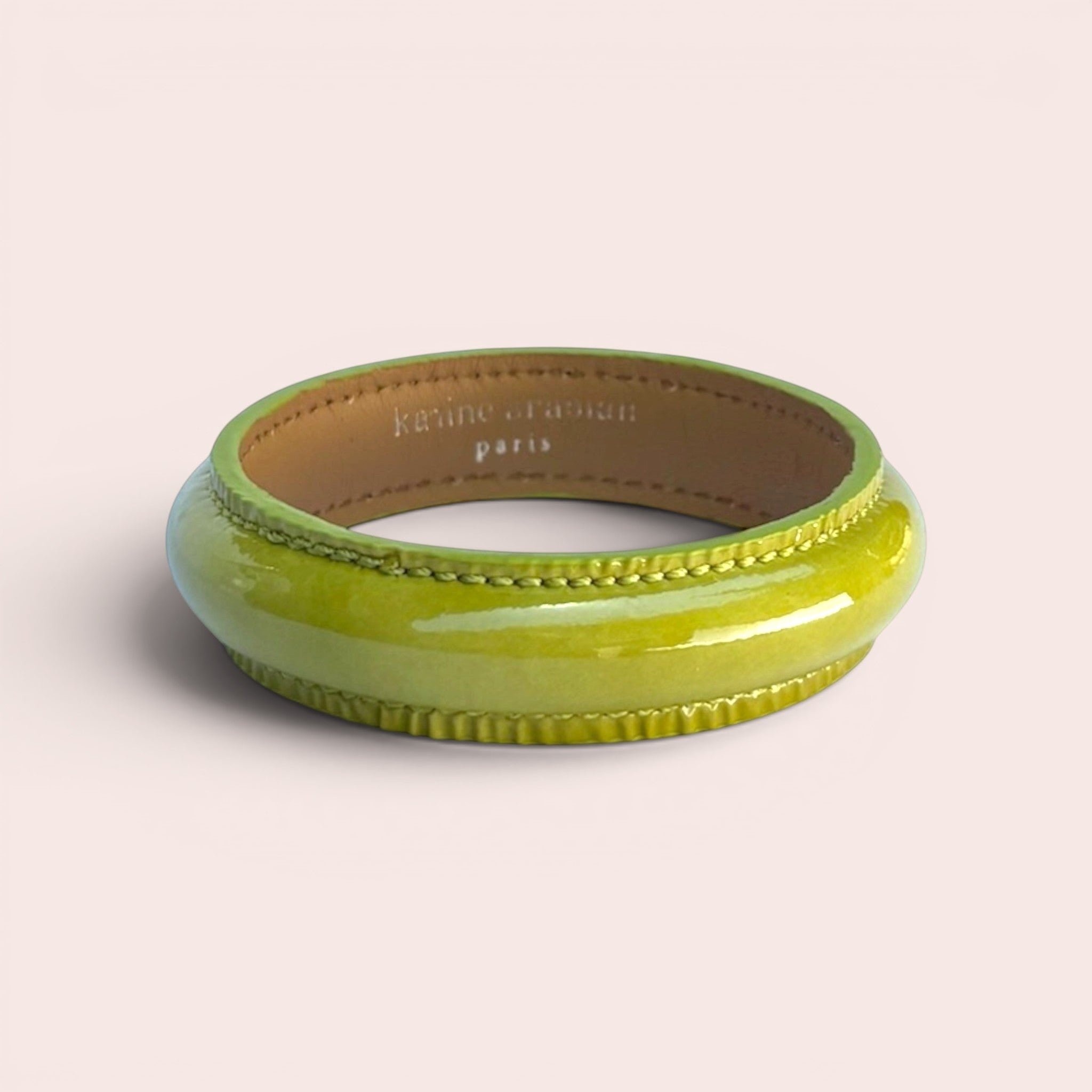 Pistachio green patent leather bangle bracelet with stitched detailing and Karine Arabian Paris branding inside.