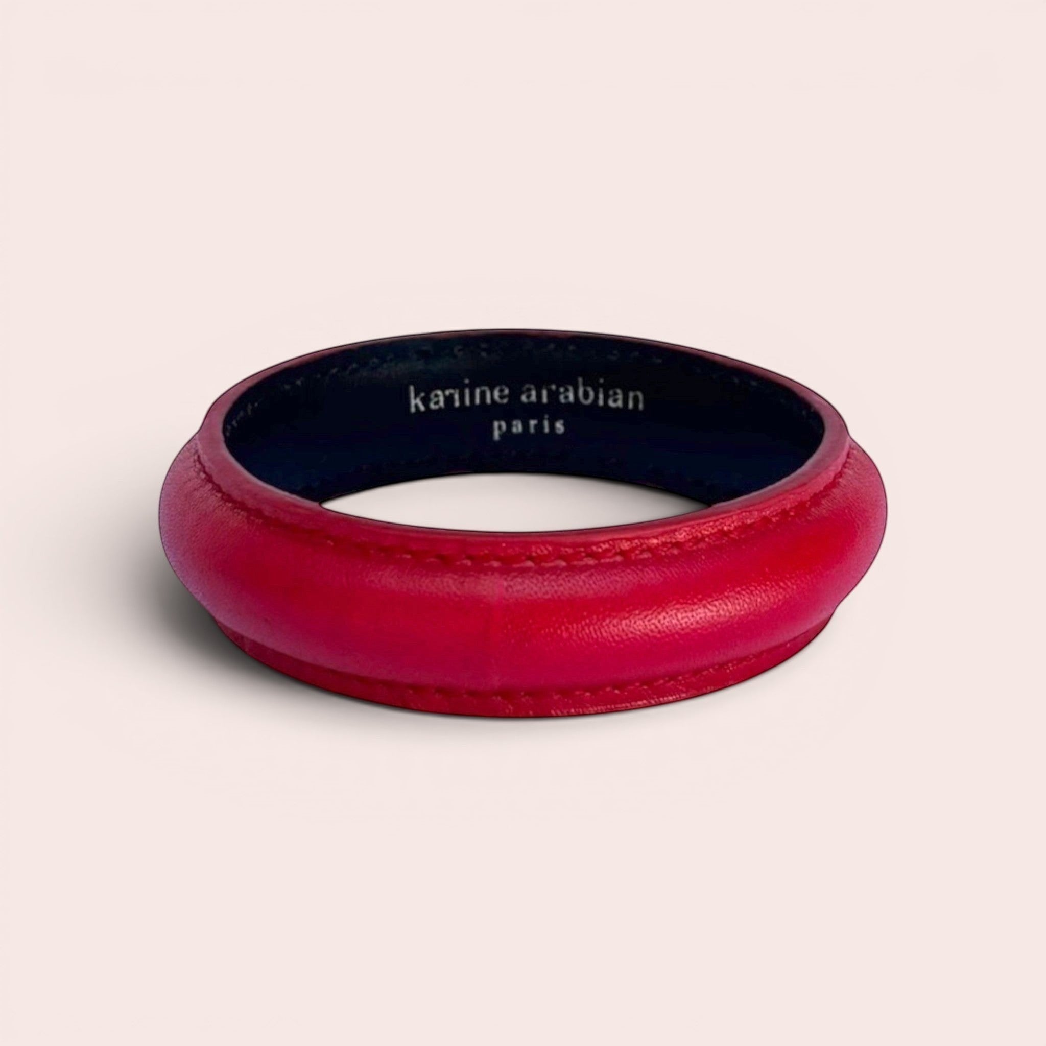 Red smooth leather bangle bracelet with Karine Arabian Paris branding on the inner lining