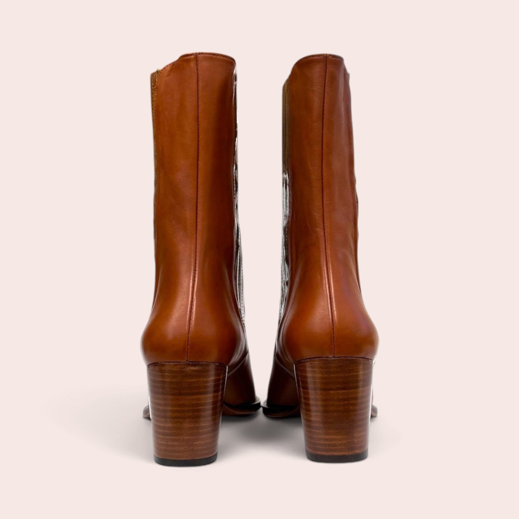 Back view of tan leather mid-calf boots with stacked block heels and textured snake-embossed side paneling