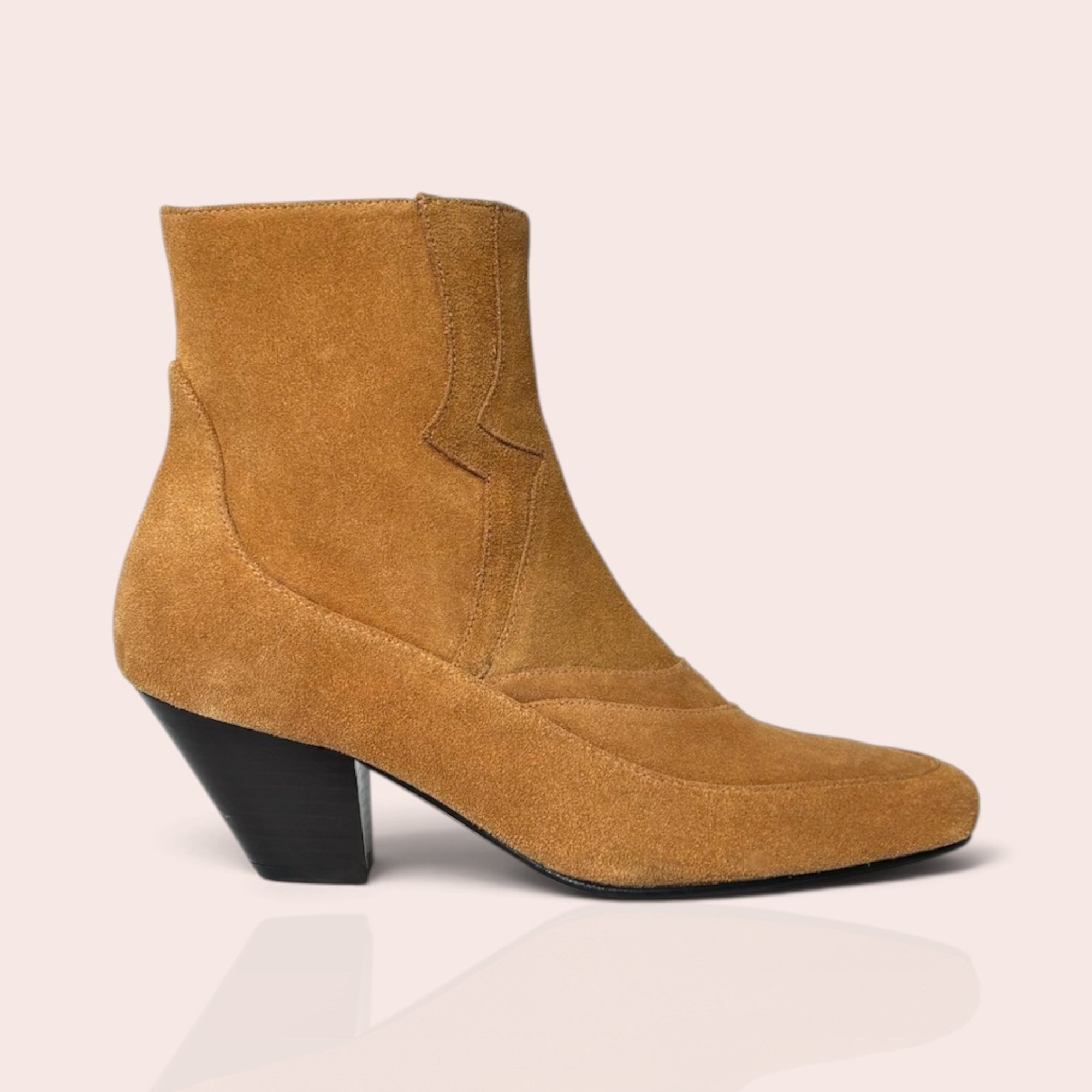 Tan suede western-style ankle boot with a pointed toe, decorative stitching, and a black sculptural block heel.