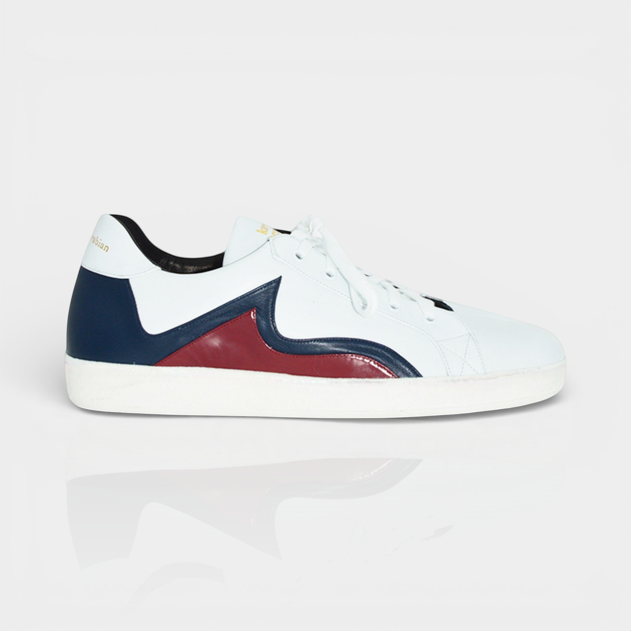 White leather sneaker with navy blue and burgundy accents, featuring a sleek design and comfortable fit.
